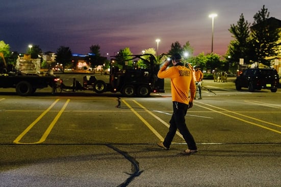 Doctor Asphalt professional asphalt paving team crack filling and seal coating commercial parking lot at night