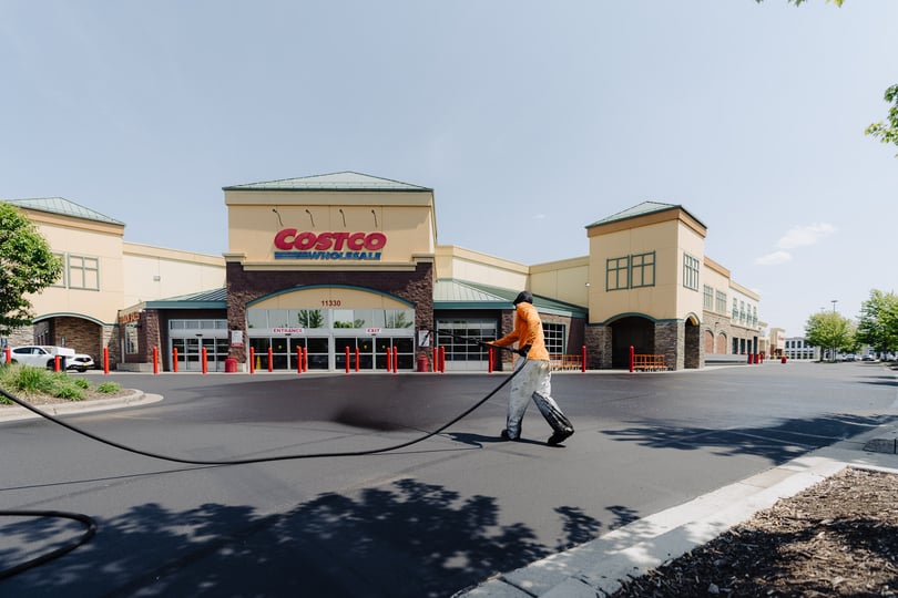 doctor asphalt team member performing maintenance on large retailer parking lot pavement