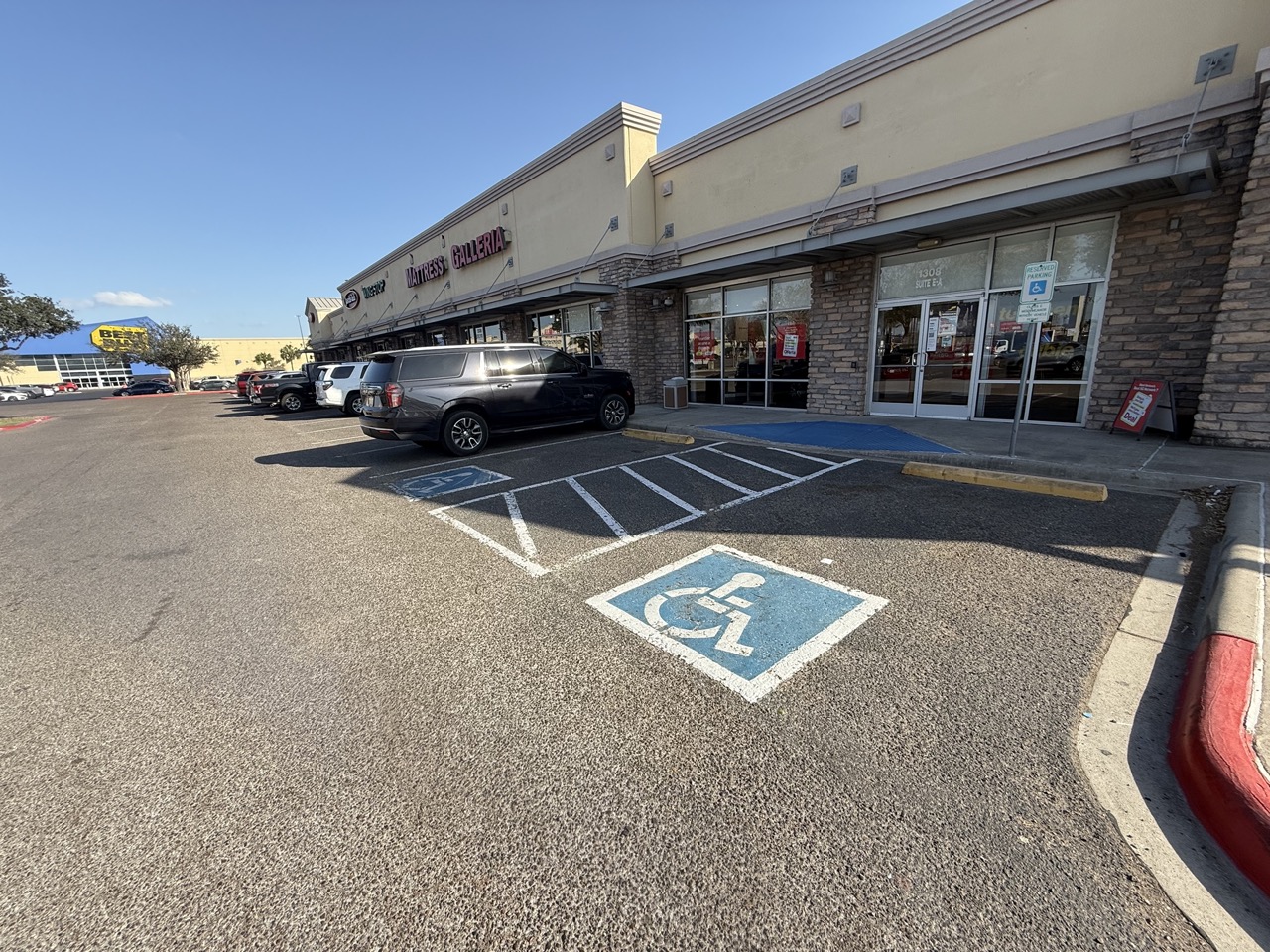 shopping center parking lot with business doors and handicap parking spots in the foreground