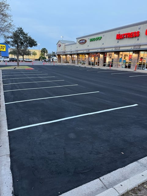 Sealcoated and line striped parking lot in front of shopping mall front