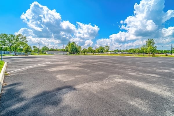 empty parking lot with worn asphalt pavement
