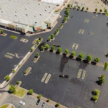 Freshly paved commercial parking lot at shopping center, aerial view