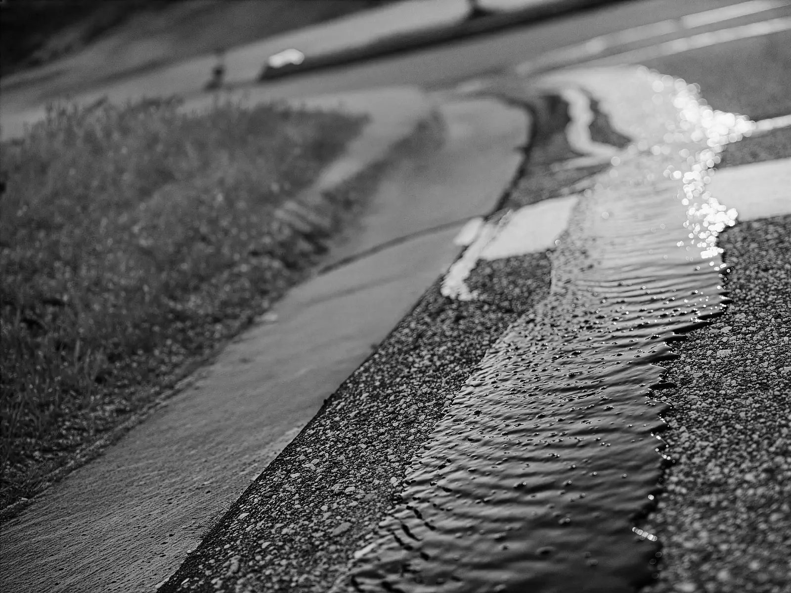 Close-up of hot pour crack sealant being applied to asphalt pavement repair