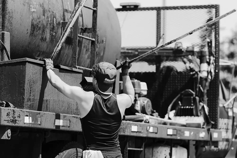 Doctor Asphalt crew member working on sealcoating tank truck equipment
