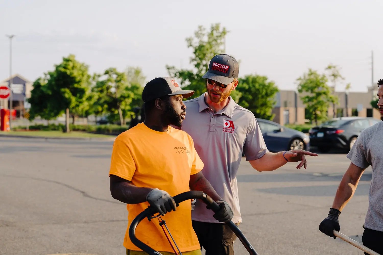 Doctor Asphalt supervisor giving directions to crew member in parking lot