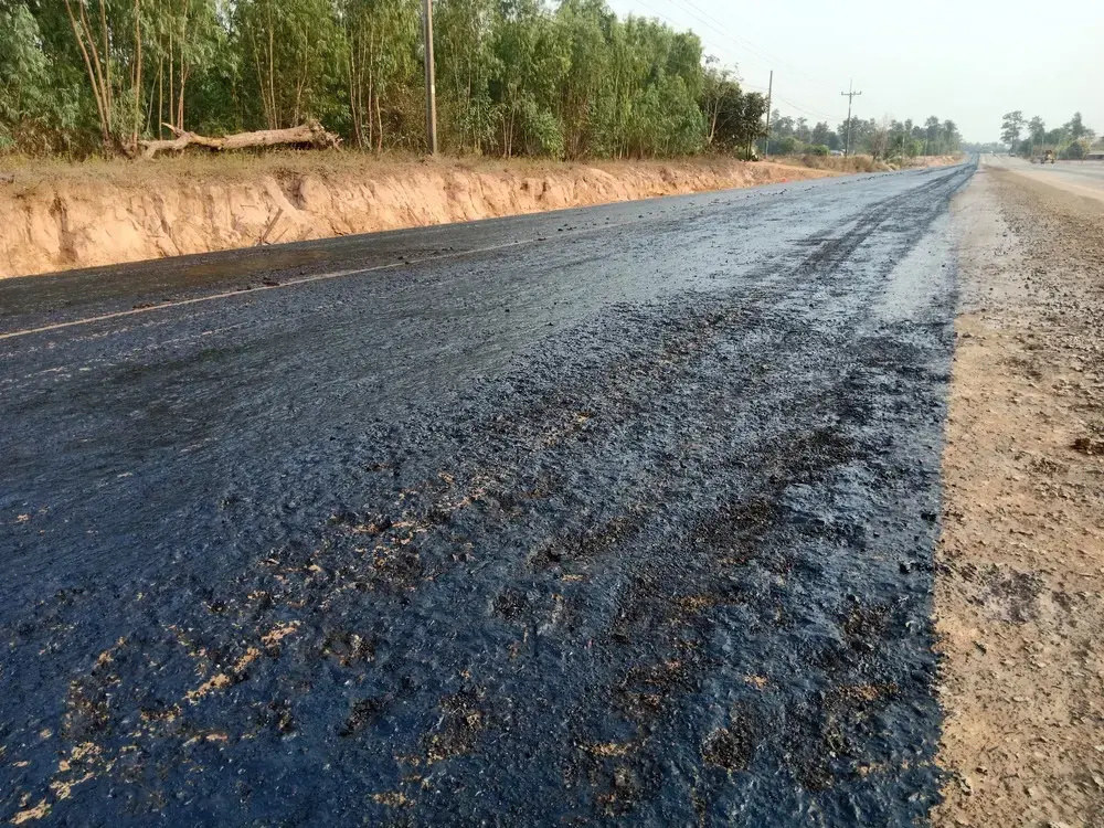 rough asphalt with oil marks and signs of asphalt bleeding